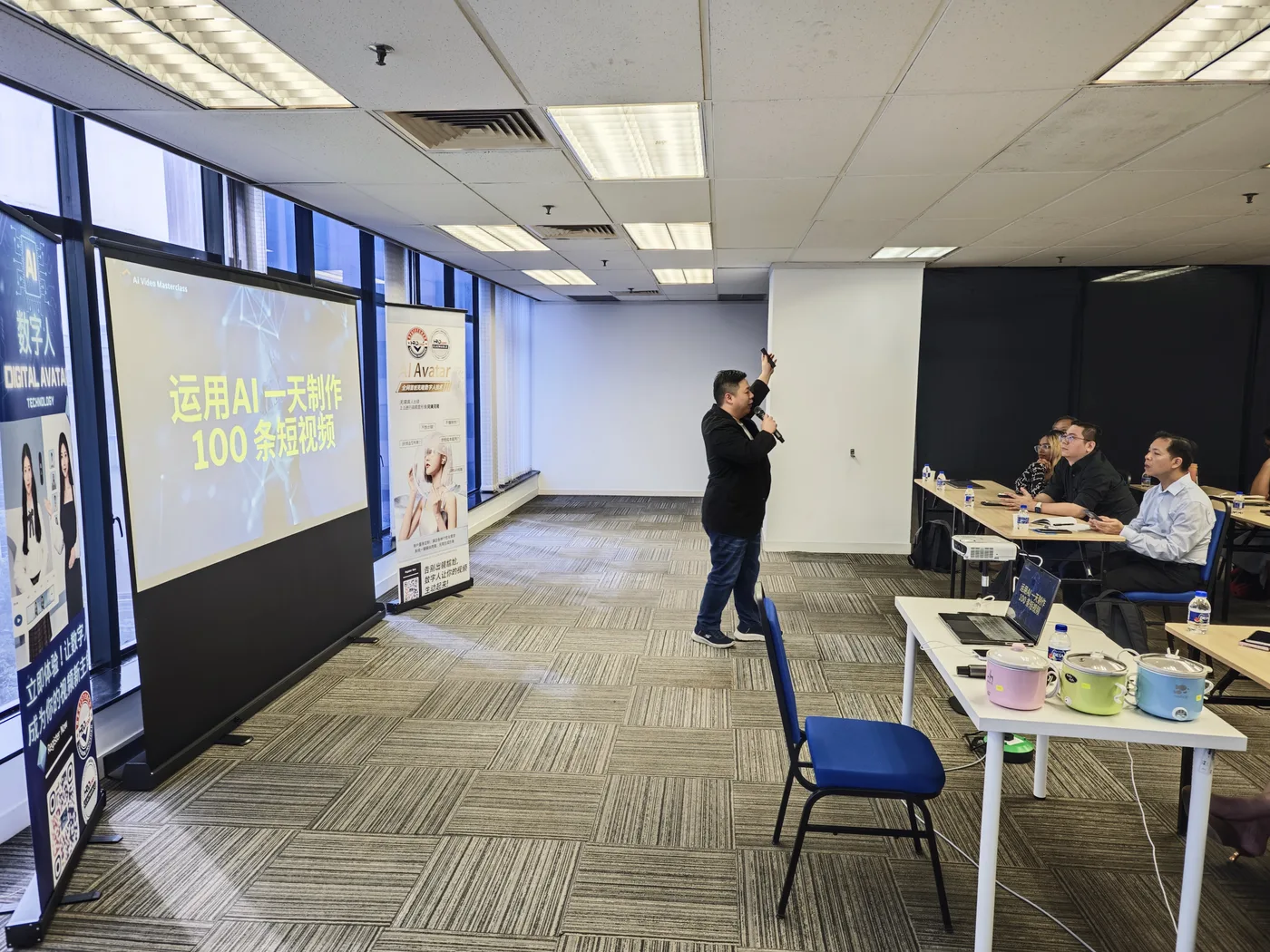 Max Ng 在「运用 AI 一天制作 100 条短视频」横幅旁讲课