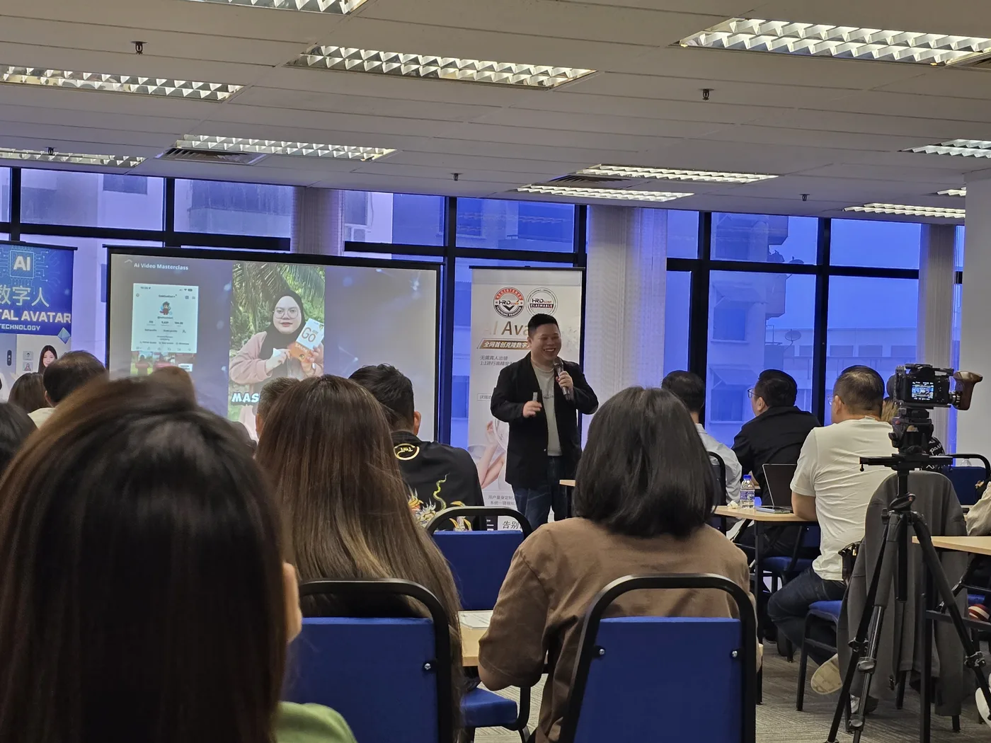 Max Ng 在数字人海报旁向学员讲解