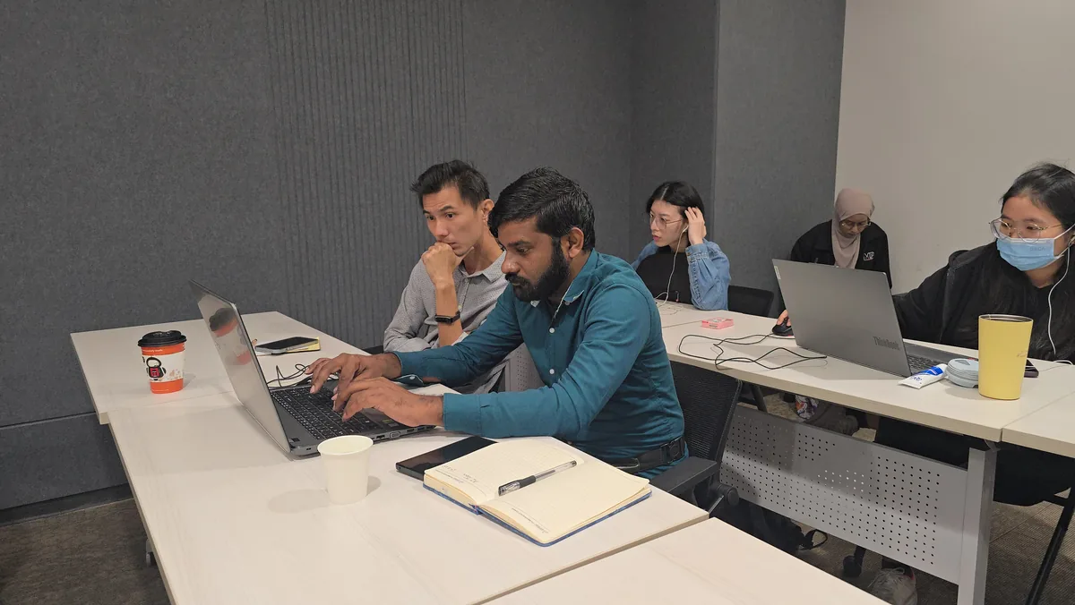 Company participants working hands-on on their laptops during the AI session