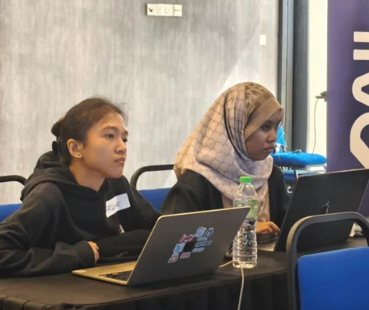 Two participants building their AI videos during the hands-on session